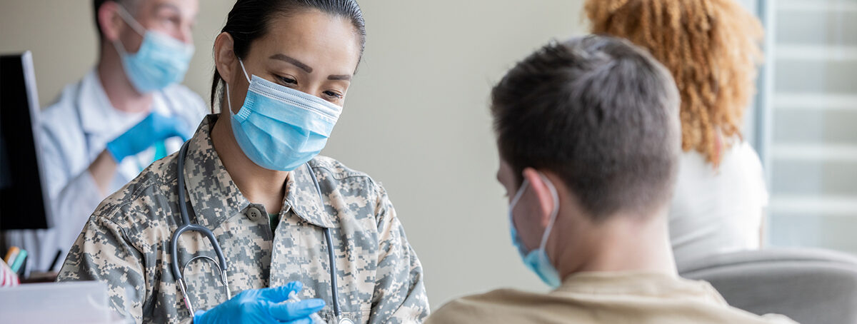 Mature soldier is military doctor giving COVID 19 vaccine injections