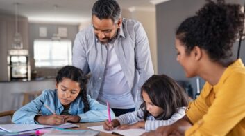 mixed race parents helping children in homework at home picture id1270069171