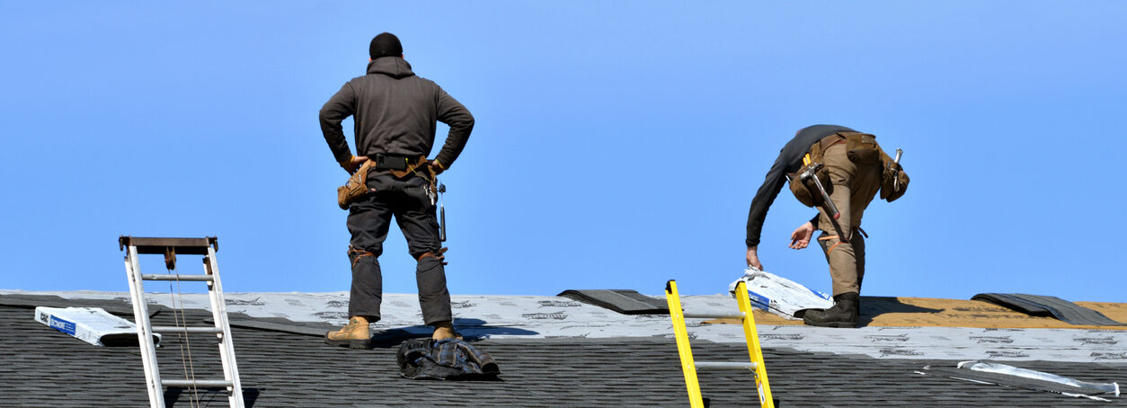 Two Men Roofing a House in the Sunshine